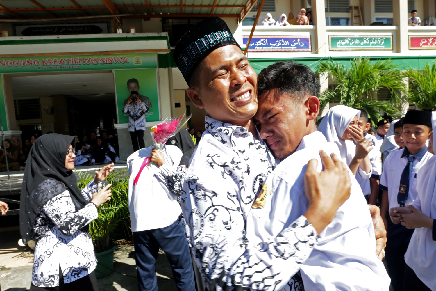 Pelajar memberikan ucapan selamat dengan memeluk gurunya seusai upacara peringatan hari guru nasional dan HUT Persatuan Guru Republik Indonesia (PGRI) di MTsN Model, Banda Aceh, Aceh, Senin (25/11/2019). Peringatan hari guru nasional yang bertepatan dengan HUT ke-74 PGRI menjadi momentum memberikan penghargaan dan ungkapan terima kasih kepada guru yang telah mendidik serta meningkatkan kualitas sumber daya manusia generasi penerus pembangunan bangsa. Foto Pilihan Pekan Keempat November 2019