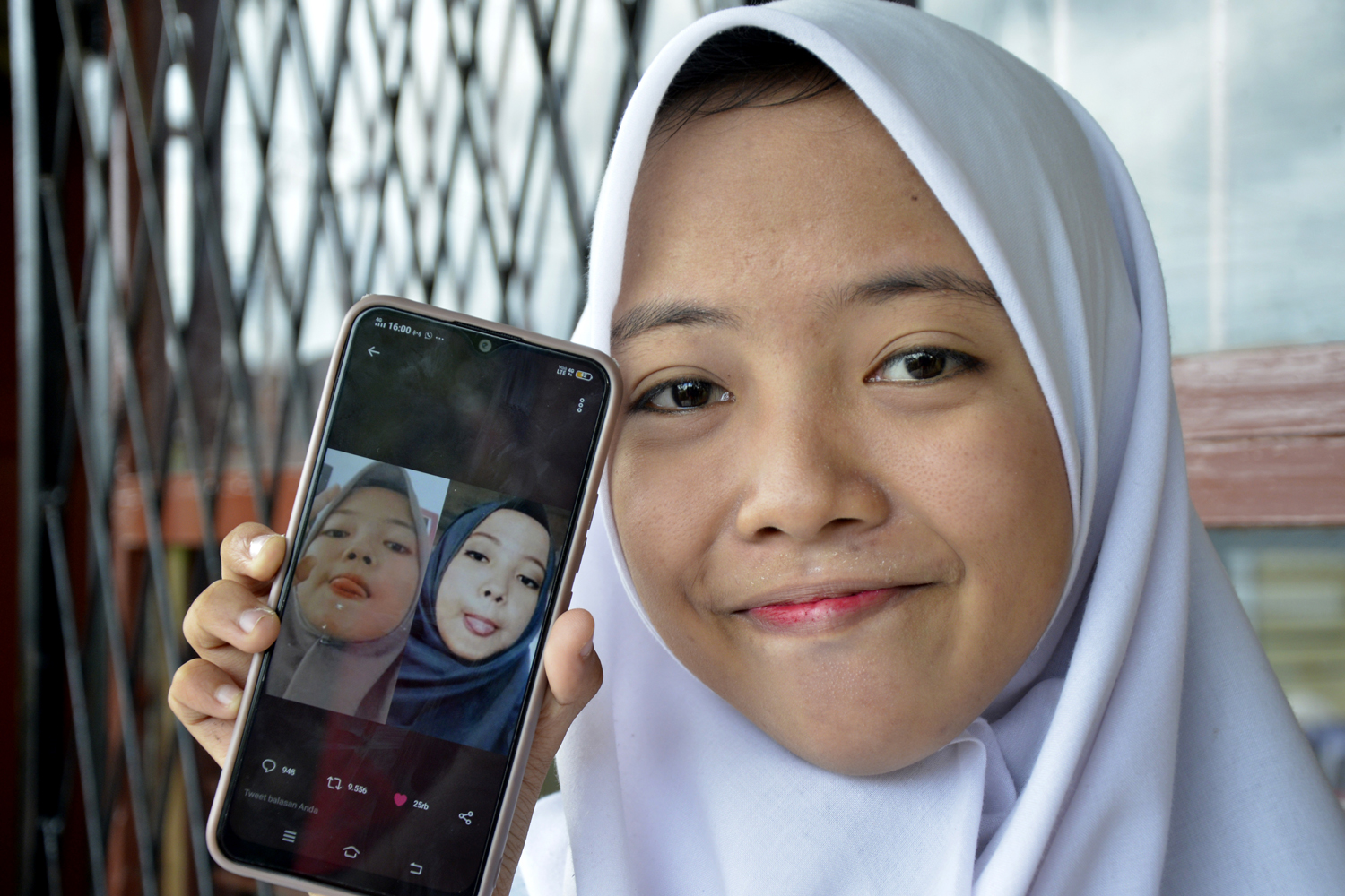 Nabila Azzahrah (16) memperlihatkan foto saudara kembarnya yang ditemuinya melalui media sosial twitter, di Kabupaten Gowa, Sulawesi Selatan, Senin (13/1/2020). Tiga saudara kembar terpisah sejak lahir selama 16 tahun karena diadopsi oleh keluarga berbeda, Nabila Azzahrah menetap di Sulsel sedangkan saudara kembarnya Nadya Tri Elvira di Depok, sementara saudara kembar satunya masih dicari. Foto Pilihan Pekan Ketiga Januari 2020