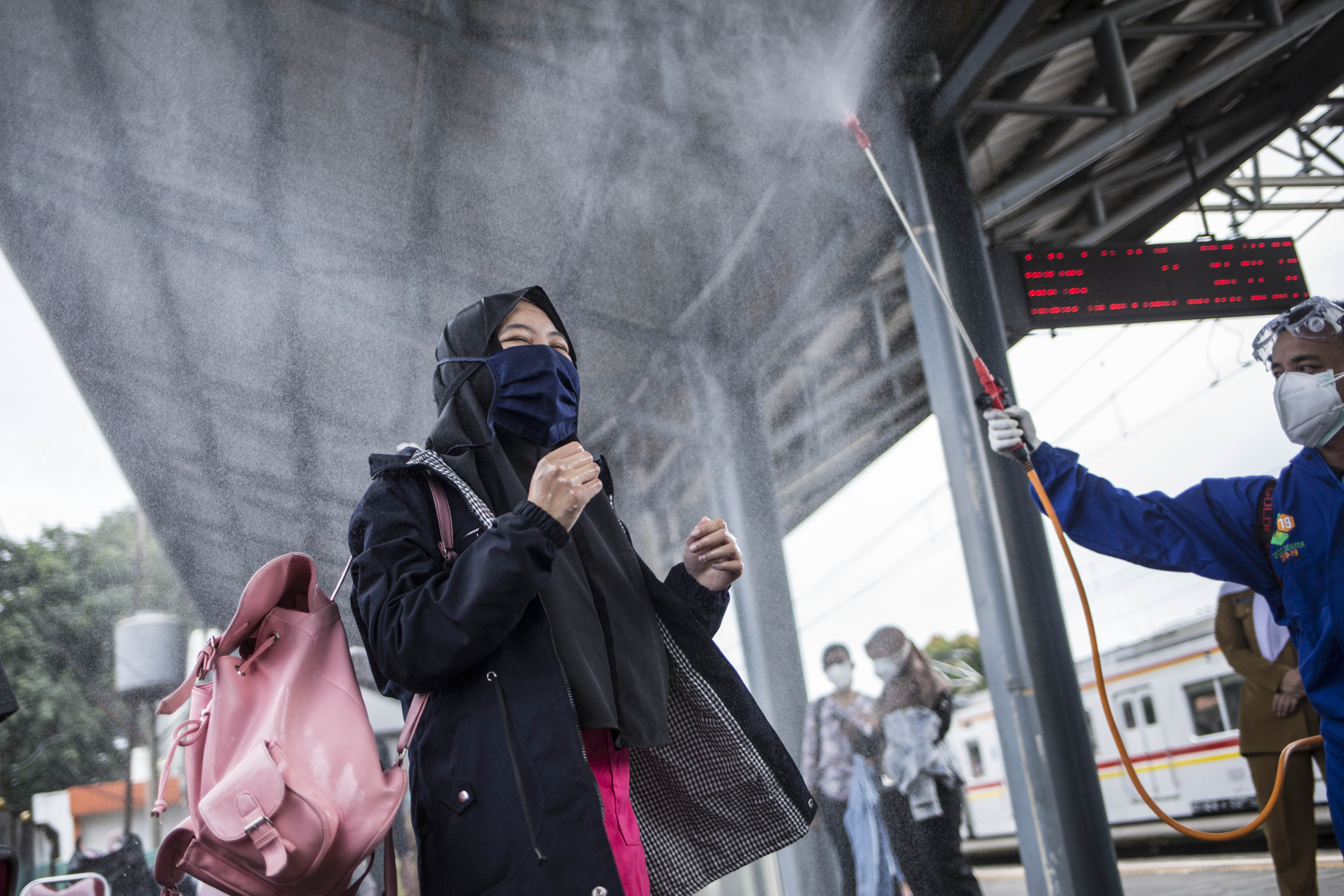 Petugas menyemprotkan disinfektan kepada penumpang KRL Commuter Line setelah melakukan swab tes masal Covid -19 di Stasiun Bojong Gede, Bogor, Jawa Barat, Senin (11/5). Tes swab tersebut dilakukan kepada 200 calon penumpang KRL secara acak sebagai salah satu langkah untuk mendeteksi dan mencegah penyebaran virus COVID-19 di transportasi umum. Swab Test Masal di Stasiun KRL Bojong Gede