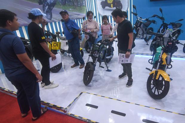 Pengunjung Jakarta Fair mengamati produk sepeda motor listrik