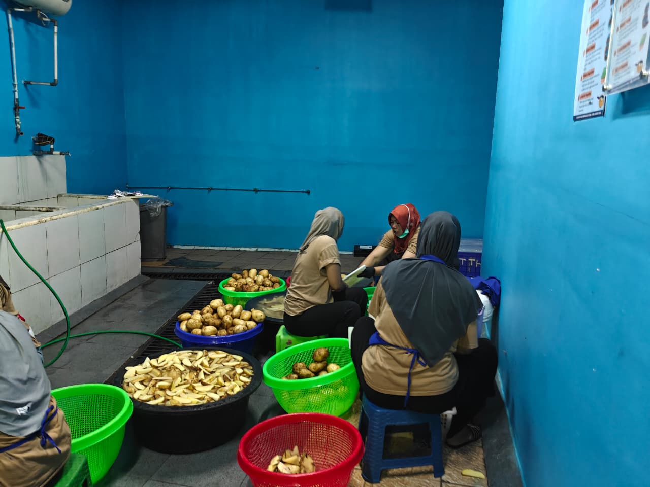 Pekerja mengupas bahan makanan di Satuan Pelayanan Pemenuhan Gizi (SPPG) di Senen, Jakarta Pusat. Foto: Andi M. Arief/katadata