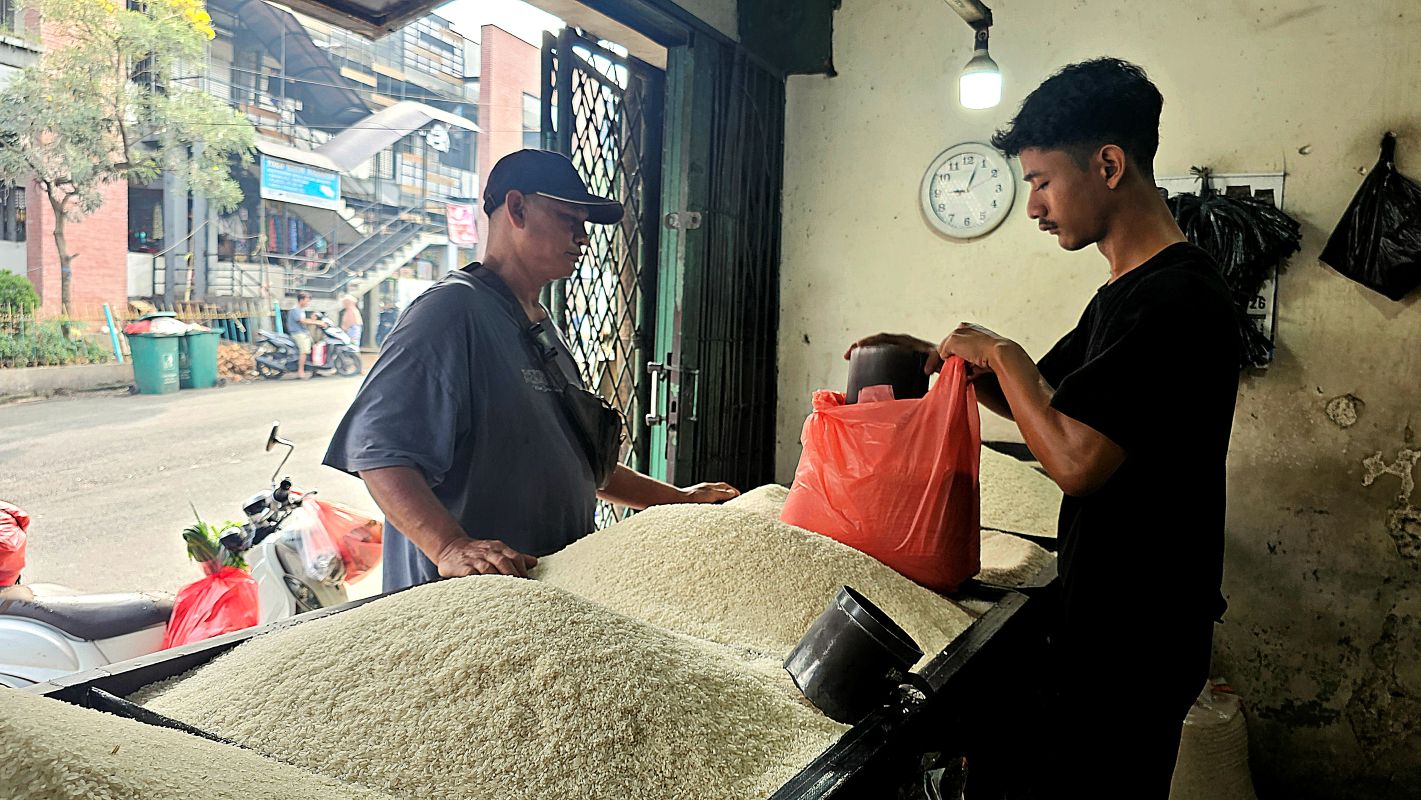 Bagus (35) melayani pembeli beras di kiosnya di Pasar Ciputat, Tangerang Selatan, Sabtu (17/5/2026). 