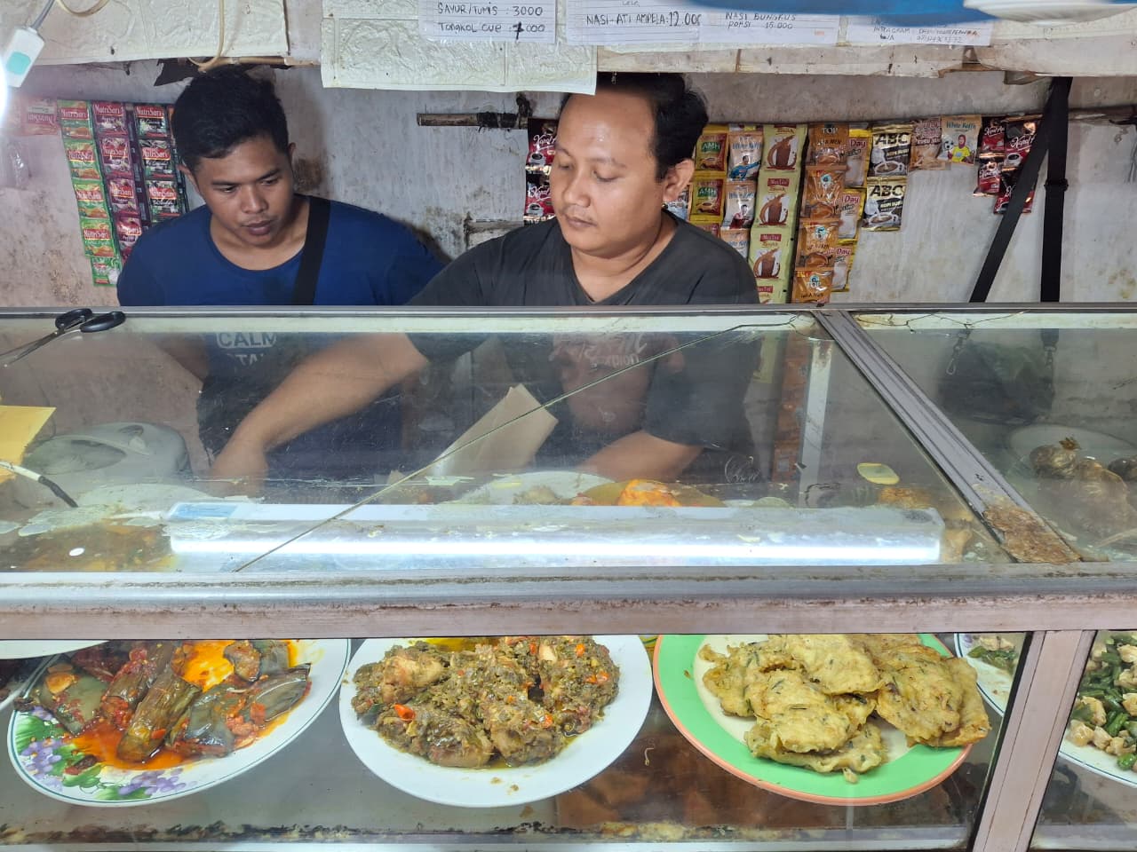 Dheni (31) melayani pelanggan yang memesan nasi bungkus.