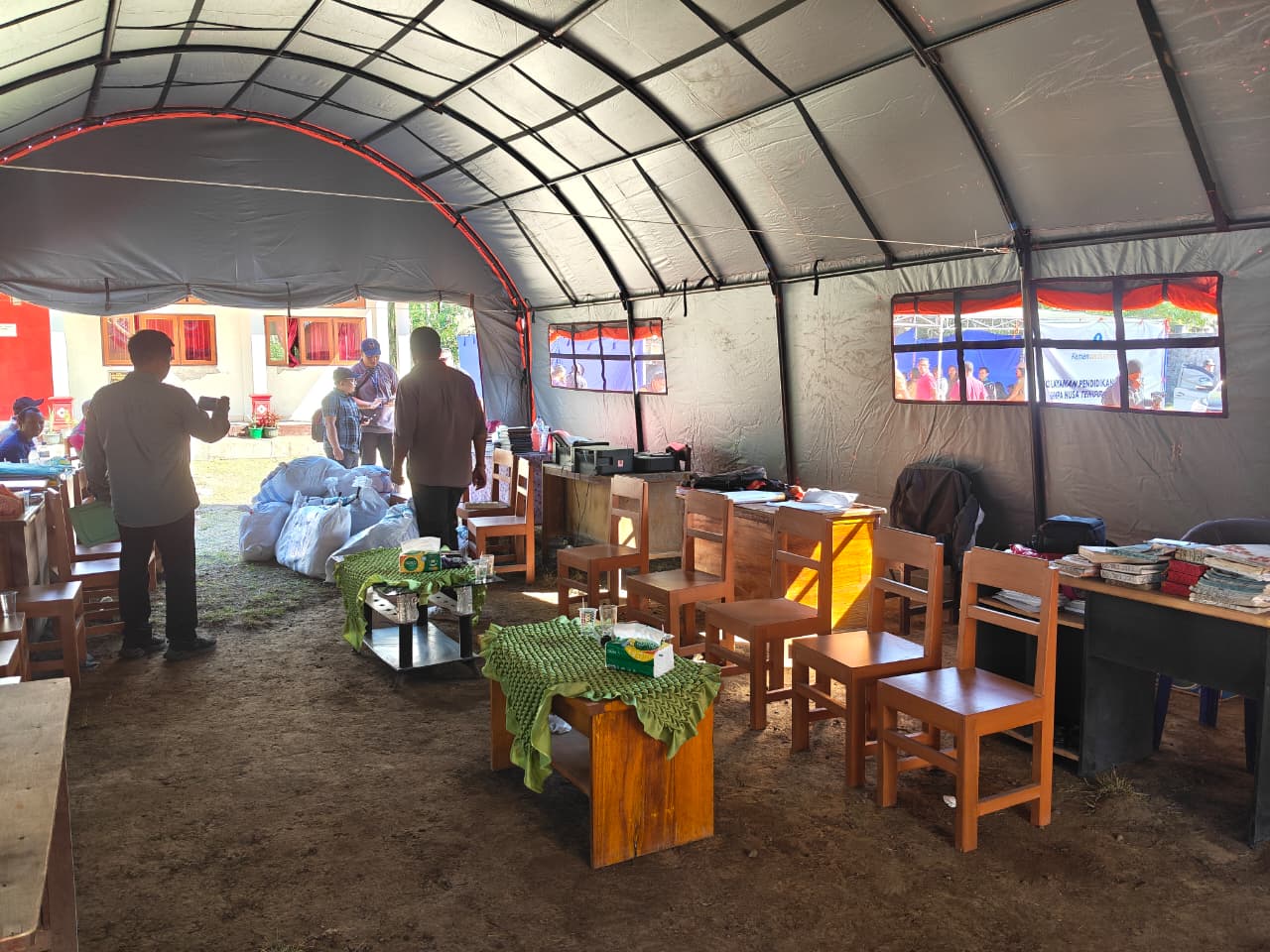 Meja dan kursi kayu berjejer di dalam tenda posko darurat yang didirikan di lingkungan SD Inpres Ngelapadhi, Kabupaten Ngada, Senin (24/8).
