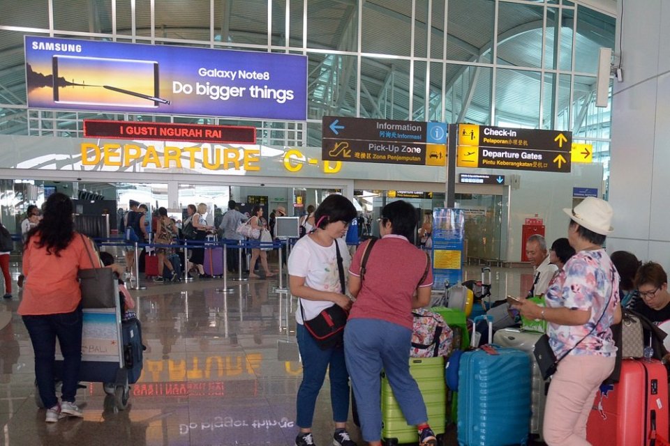 Sejumlah calon penumpang menunggu jadwal penerbangan di terminal keberangkatan internasional Bandara Ngurah Rai, Tuban, Bali, Minggu (26/11). 