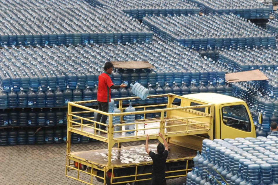 Pekerja menukar galon air kemasan yang kosong dengan baru di kawasan kalibata, Jakarta Selatan, Selasa (25/2). Saat ini total pasar air minum dalam kemasan (AMDK) di Indonesia mencapai 20 miliar liter air dengan pertumbuhan 12 persen per tahun.