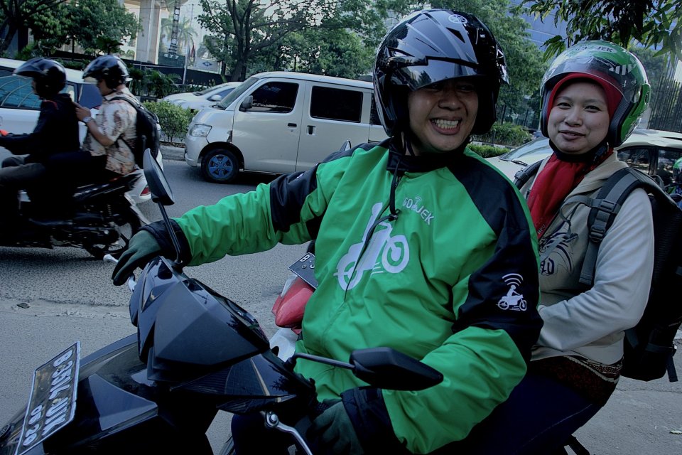 Pengemudi ojek Go-Jek mengantarkan penumpang menuju salah satu kawasan perkantoran di Jakarta, Jumat (26/06/2015).