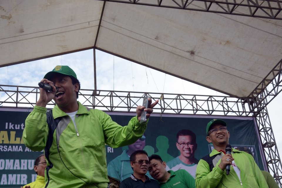 Ketua Umum DPP PPP Muhammad Romahurmuziy (kiri) didampingi anggota DPR Amir Uskara (kanan) menghibur massa dengan bernyanyi usai mengikuti Jalan Santai Bersama PPP di Desa Pallangga, Kabupaten Gowa, Sulawesi Selatan, Minggu (5/3/2018).