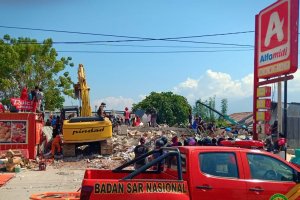 Warga mengambil makanan dari minimarket yang ambruk di Palu, Sulawesi Tengah, Minggu (30/9). Warga diperkirakan terpaksa mengambil makanan lantaran te