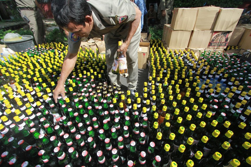 Petugas Satuan Polisi Pamong Praja (Satpol PP) menata botol berisi minuman keras yang akan dimusnahkan di kantor Bupati Gorontalo, Kabupaten Gorontalo, Gorontalo.