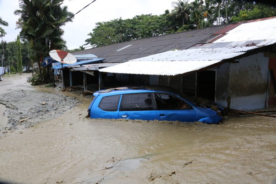 Sebuah mobil tenggelam oleh banjir di Sentani, Papua, Selasa (19/3).