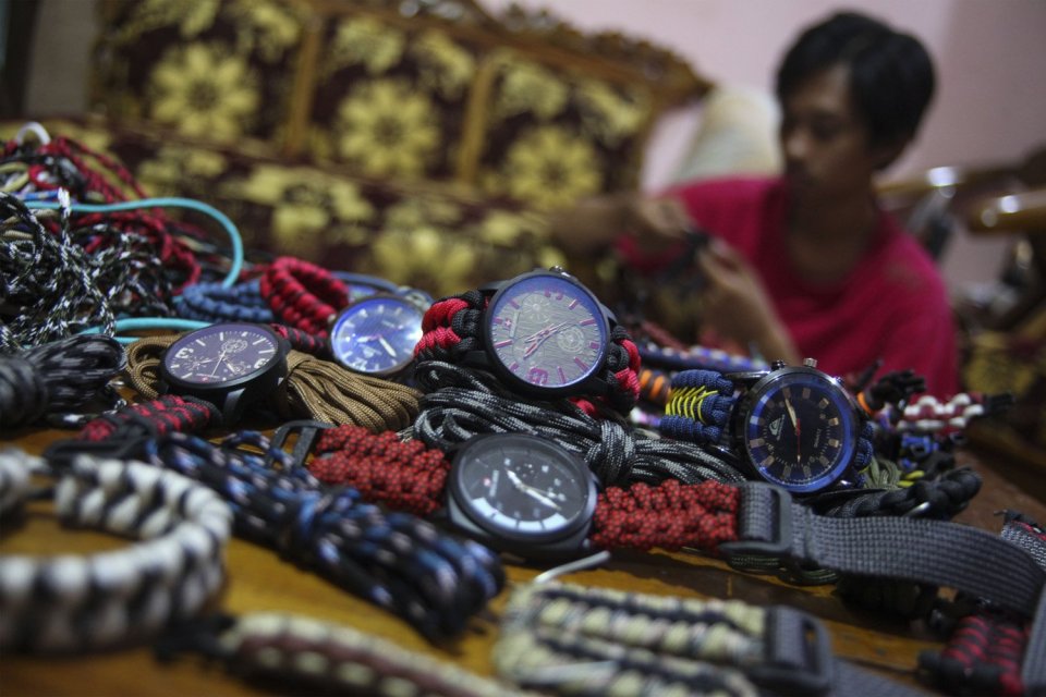 Perajin membuat strap jam tangan dari tali paracord yang dijual secara daring dari studio Bakul Gelang di Solo, Jawa Tengah, Selasa (18/12/18). Kerajinan jam tangan tali paracord itu dijual seharga Rp100.000 - Rp150.000 per unit tergantung tingkat kerumit