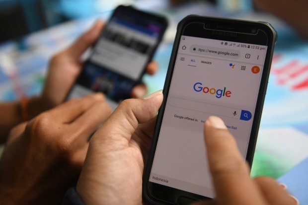 Dua orang membuka laman Google dan aplikasi Facebook melalui gawainya di Jakarta, Jumat (12/4/2019). Pemerintah menerbitkan Peraturan Menteri Keuangan tentang Badan Usaha Tetap (BUT) untuk mengejar pemasukan pajak dari perusahaan asing yang berbasis di lu