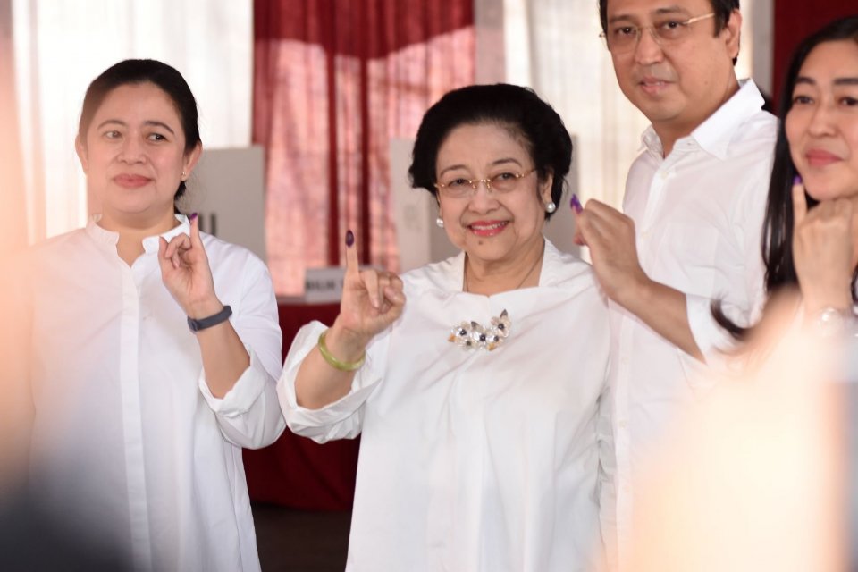 Ketua Umum PDI Perjuangan yang juga Presiden kelima RI Megawati Soekarnoputri (tengah) bersama putrinya Puan Maharani (kiri) dan putranya Muhammad Prananda Prabowo (kedua kanan) menunjukkan jarinya yang telah dicelup tinta seusai menggunakan hak pilihnya 