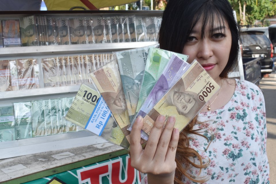 Penjual jasa penukaran uang baruyang banyak dibutuhkan selama Lebaran di sekitar Alun-alun Kota Madiun, Jawa Timur, Senin (13/5/2019). Penjual jasa tersebut memungut tambahan 10 persen dari jumlah uang yang ditukarkan untuk uang pecahan Rp2.000, Rp5.000, 