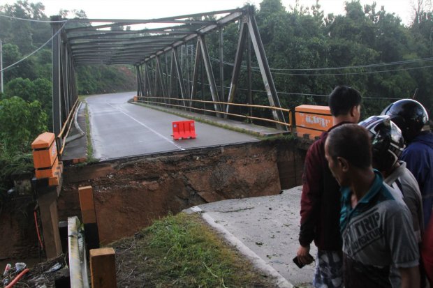 Warga melihat jembatan Ameroro yang menjadi akses jalan trans sulawesi yang rusak akibat banjir bandang di Desa Ameroro, Konawe, Sulawesi Tenggara, Senin (10/6/2019). Sungai Konaweha meluap akibat banjir bandang menyebabkan akses jalan trans sulawesi yang