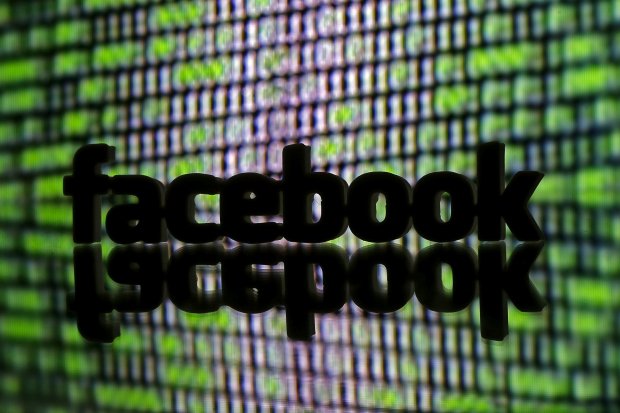 Logo Facebook yang dicetak 3D berdiri terlihat di depan kode siber yang dipajang dalam sebuah ilustrasi yang diambil fotonya tanggal 22 Maret 2016. 