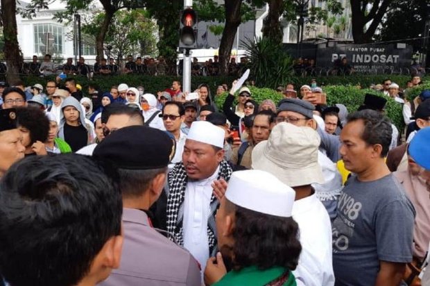 Pengunjuk rasa terkait sidang sengketa Pilpres di MK sedang bernegosiasi dengan salah satu anggota kepolisian, di Jakarta, Rabu (26/6).