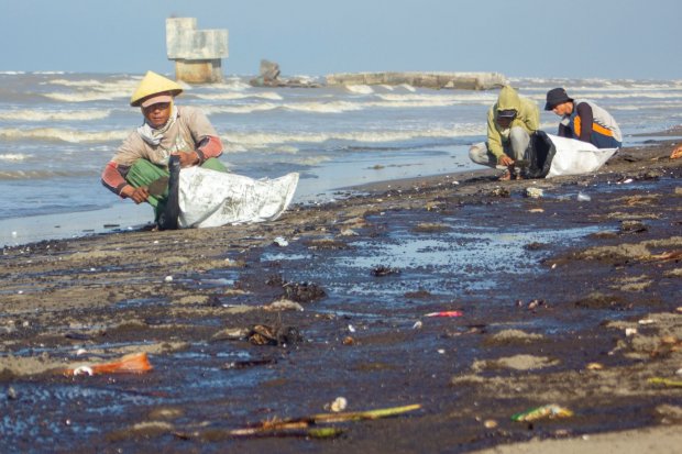 Warga mengumpulkan tumpahan minyak (Oil Spill) yang tercecer di Pesisir Pantai Cemarajaya, Karawang, Jawa Barat, Senin (22/7/2019). Tumpahan minyak tersebut tercecer di sepanjang pantai Sedari hingga pantai Cemarajaya akibat kebocoran pipa proyek eksplora