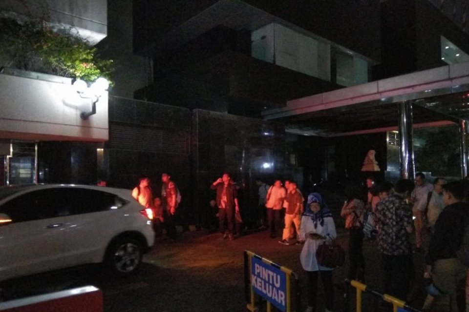 Penghuni Wisma Antara, Jakarta Pusat, berkumpul di parkiran luar pada Jumat (2/8) malam akibat guncangan gempa bumi bermagnitudo 7,4 yang berpusat di Sumur, Banten, terasa sampai ibu kota. 