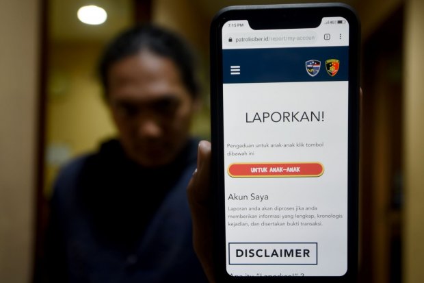 Warga menunjukkan aplikasi situs patrolisiber.id saat peluncuran di kantor Bareskrim Polri, Jalan Trunojoyo, Jakarta Selatan, Rabu (14/8/2019). Situs tersebut dibuat untuk menampung aduan kejahatan siber dari masyarakat sekaligus bentuk pencegahan kejahat