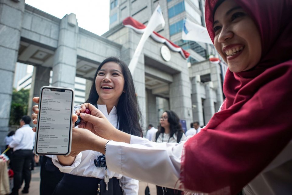Pegawai Bank Indonesia (BI) menunjukkan bukti transaksi menggunakan peluncuran QR Code Indonesian Standard (QRIS) di halaman Gedung Bank Indonesia, Jakarta, Sabtu (17/8/2019). 