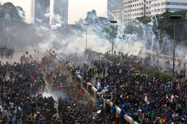 Polisi melontarkan gas air mata saat kericuhan dalam unjuk rasa di depan kompleks Parlemen di Jakarta, Selasa (24/9/2019). Ribuan mahasiswa yang berasal dari kampus di sejumlah daerah itu turun ke jalan berdemonstrasi menolak UU KPK dan pengesahan RUU KUH