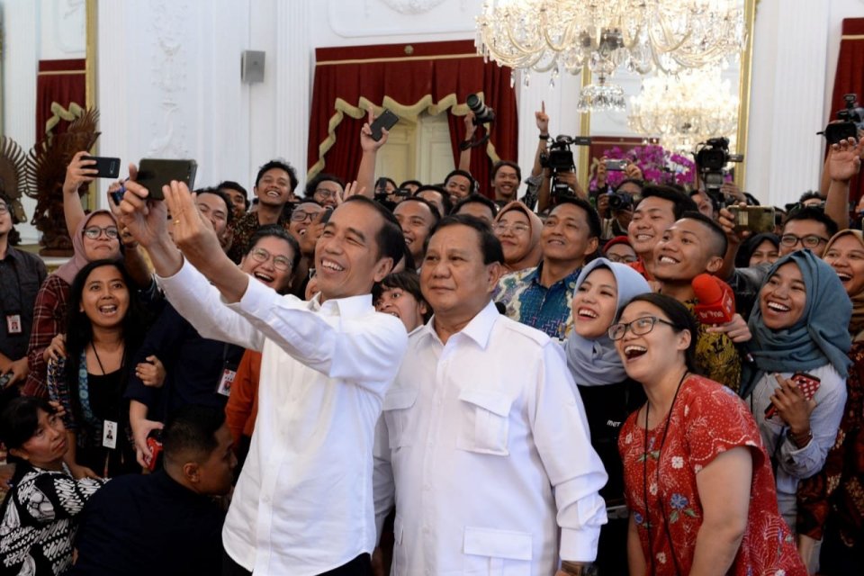 Presiden Joko Widodo dan Ketua Umum Partai Gerindra Prabowo Subianto berswafoto bersama para wartawan di Istana Merdeka, Jakarta, Jumat (11/10).