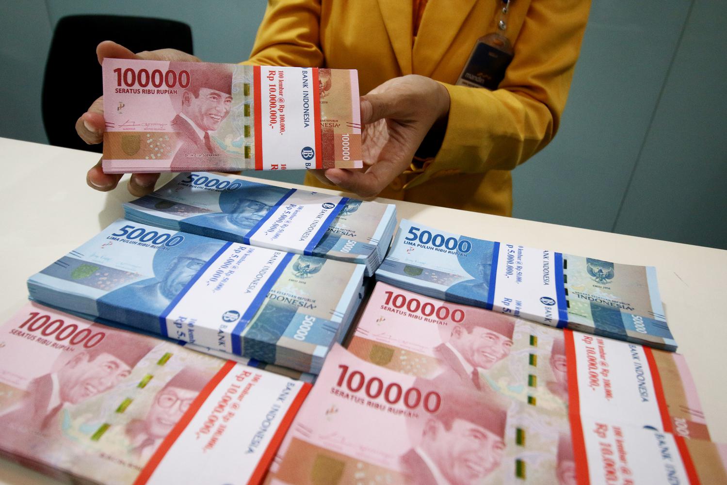 Karyawan menunjukan uang rupiah pecahan 100 ribu dan 50 ribu di Plaza Mandiri, Jakarta, Senin (23/9/2019). Nilai tukar rupiah yang ditransaksikan antar bank di Jakarta pada awal pekan ini dibayangi sentimen perang dagang, terkait batalnya kunjungan deleg