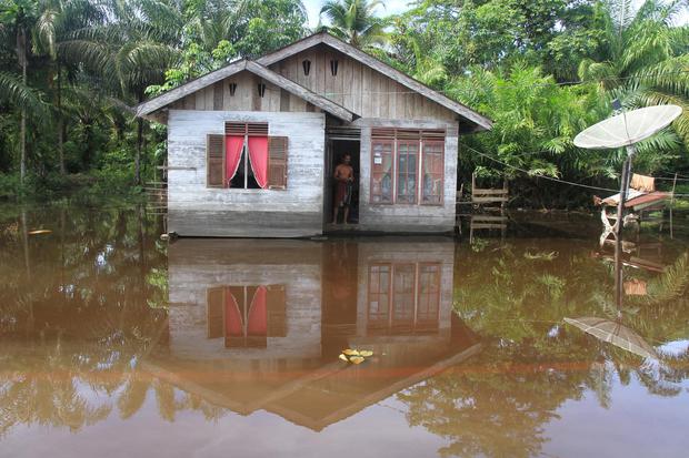 Warga berada di rumahnya yang terendam banjir di Desa Gunong Pulo, Kecamatan Arongan Lam Balek, Aceh Barat, Aceh, Kamis (31/10/2019). Banjir yang disebabkan tingginya intensitas hujan sejak dua pekan terakhir menyebabkan ratusan rumah warga dan ratusan he