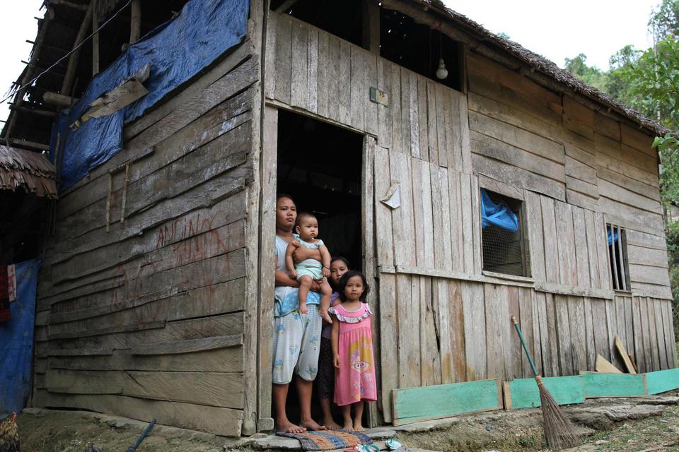 Darmayanti bersama tiga orang anak yang belum pernah mendapatkan bantuan apapun dari Dana Desa berada di pintu rumahnya di Desa Andobeu Jaya, Kecamatan Anggomoare, Kabupaten Konawe, Sulawesi Tenggara, Kamis (7/11/2019).