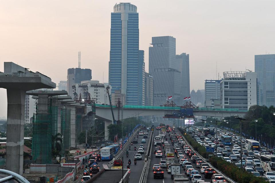 Sejumlah kendaraan bermotor melintas dengan latar belakang pembangunan 'longspan' atau bentangan beton panjang lintasan Light Rail Transit (LRT) di Kuningan, Jakarta, Kamis (7/11/2019). Menurut situs resmi LRT Jabodebek, lintasan LRT Kuningan merupakan 