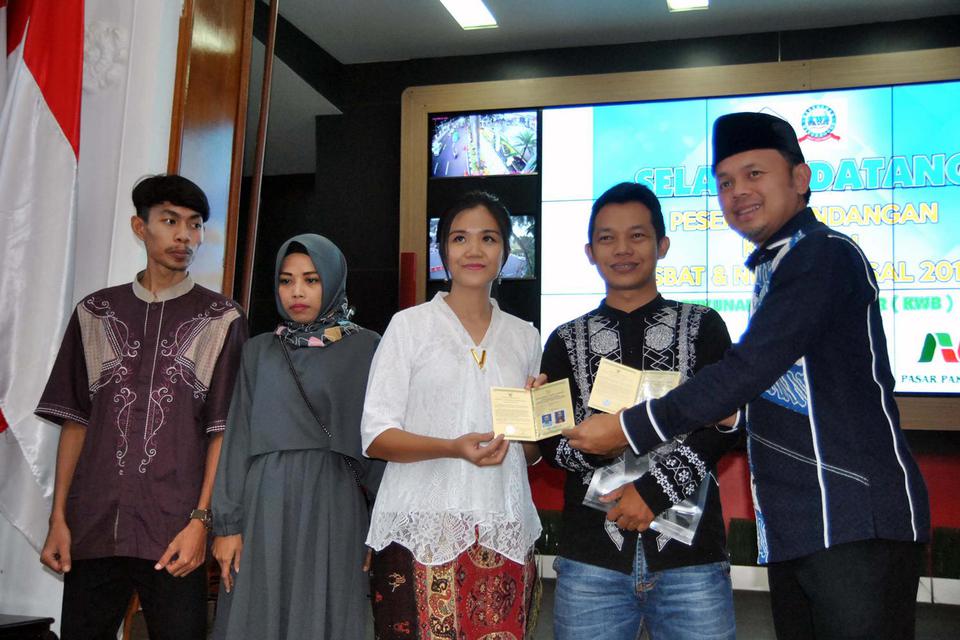 Wali Kota Bogor Bima Arya (kanan) menyerahkan buku nikah kepada peserta itsbat dan nikah massal di Bogor, Jawa Barat, Sabtu (16/11/2019). Aktivis Aliansi Masyarakat Adat Nusantara (AMAN), menilai pemerintah mengintervensi terlalu jauh dalam wacana penerap