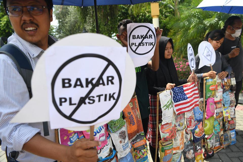 Aktivis lingkungan yang tergabung dalam Ecoton menampilkan sampah plastik impor saat aksi terkait dioksin yang dihasilkan dari pembakaran sampah plastik di Surabaya, Jawa Timur, Selasa (19/11/2019). 