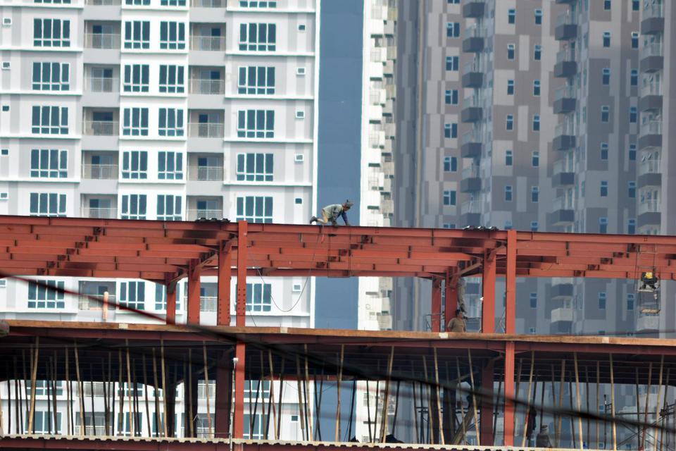 Seorang pekerja tanpa menggunakan alat pengaman ketika bekerja di rangka atap salah satu bangunan gedung bertingkat di Medan, Sumatera Utara, Selasa (19/11/2019). 