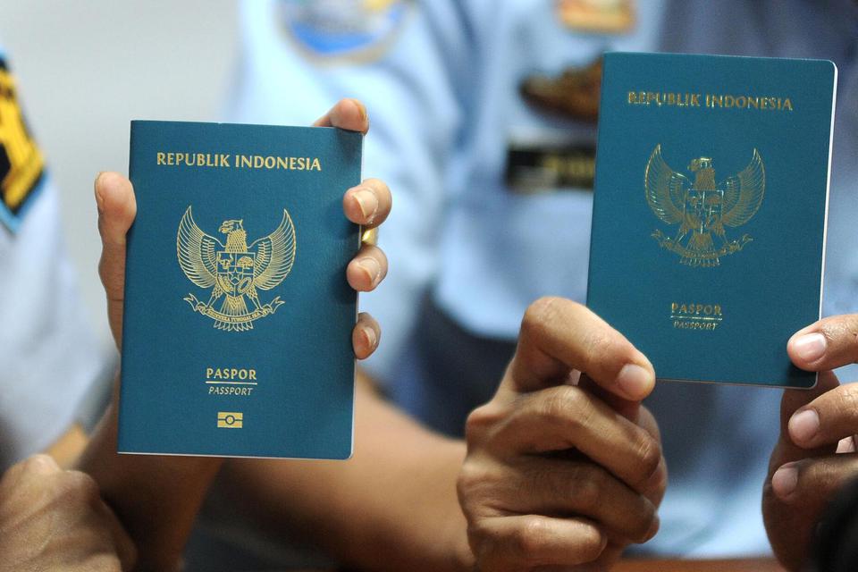 Petugas menunjukkan perbedaan Paspor Elektronik atau e-passport (kiri) dengan paspor biasa saat penerbitan Paspor Elektronik perdana di Kantor Imigrasi Kelas I Khusus Ngurah Rai, Badung, Bali, Rabu (20/11/2019). Kantor Imigrasi Kelas I Khusus Ngurah Rai, 