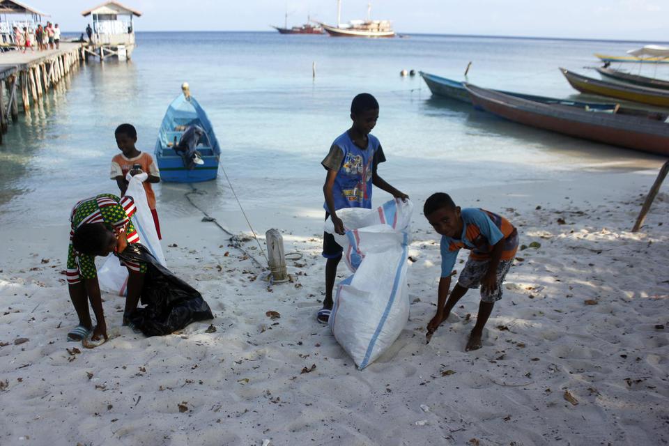 Anak-anak SD Inpres 02 Yenbuba memungut sampah di pantai Sawendarek, Kabupaten Raja Ampat, Papua Barat, Jumat (22/11/2019). 