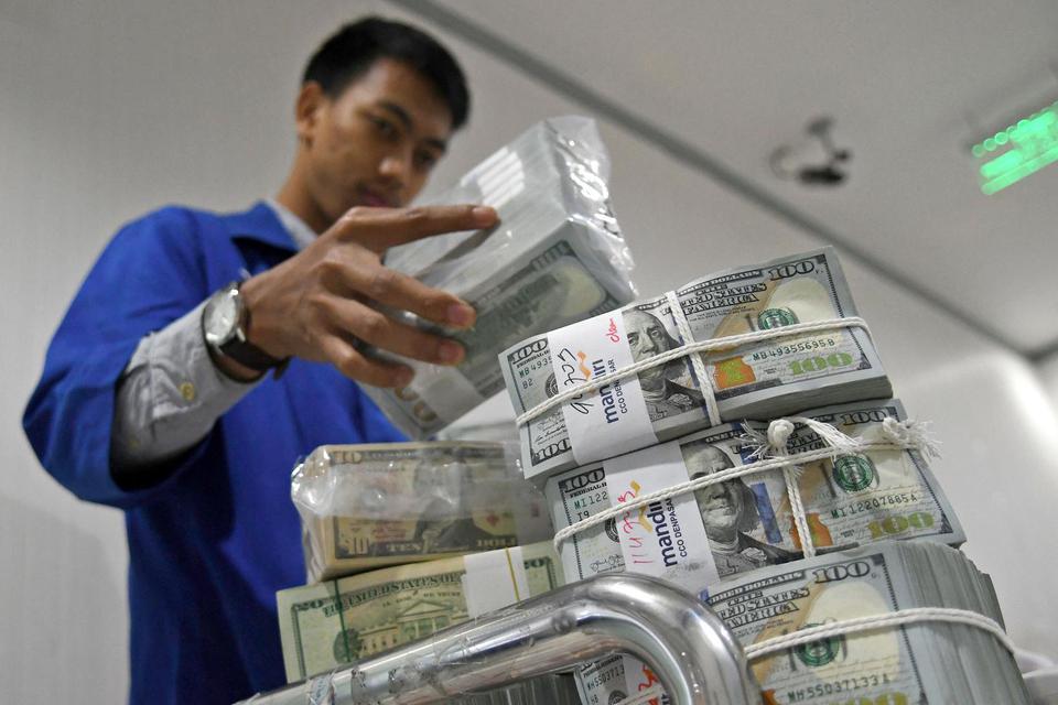 Petugas menata uang Dolar AS di Cash Pooling Bank Mandiri, Jakarta, Kamis (28/11/2019). Nilai tukar Rupiah terhadap Dolar AS menguat ke posisi Rp14.092 per Dolar AS atau 0,02 persen pada perdagangan pasar spot Kamis (28/11) sore dari sebelumnya Rp14.095 p