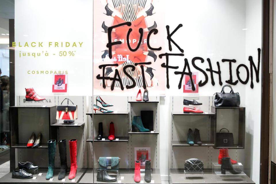 TEMPLATE OUT Slogan "Fuck Fast Fashion" (Persetan fashion cepat) terlihat di sebuah jendela toko saat aktivis "Youth for Climate" melakukan demonstrasi di dalam pusat perbelanjaan Westfield Les 4 Temps sebagai bagian dari hari protes untuk mengakhiri