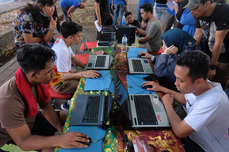 Warga mencoba menjawab soal saat mengikuti simulasi Computer Assisted Test (CAT) dalam sosialisasi seleksi CPNS 2019 pada hari bebas kendaraan, di Denpasar, Bali, Minggu (3/11/2019). Pemerintah akan membuka portal pendaftaran CPNS malam nanti pukul 23.11 