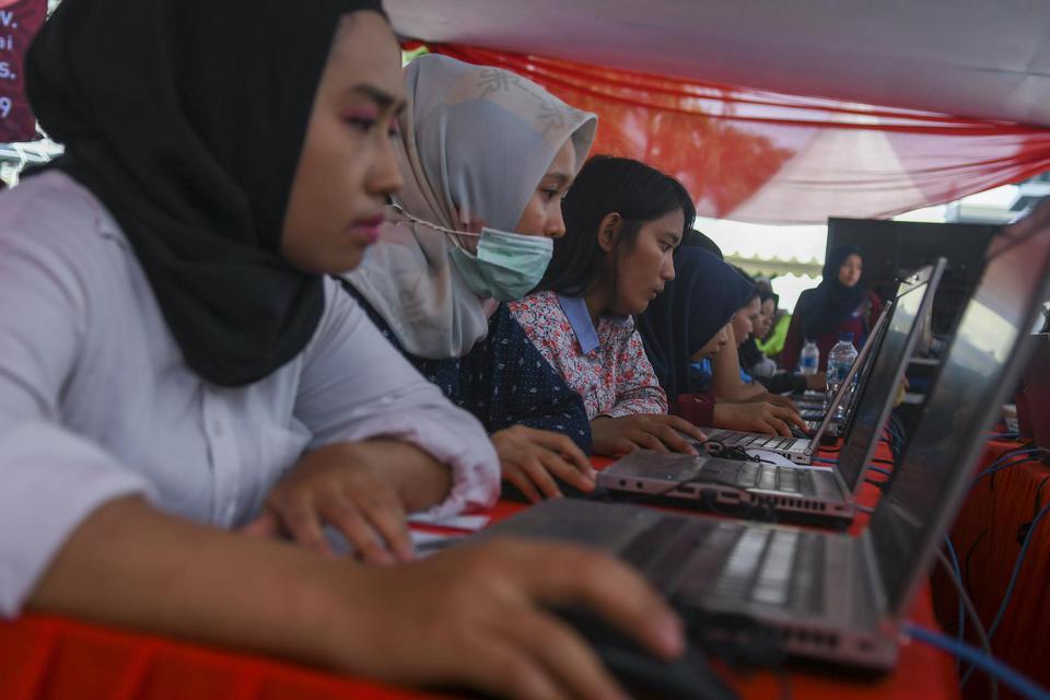Peserta mengikut simulasi tes Calon Pegawai Negeri Sipil (CPNS) berbasis Computer Assisted Test (CAT) saat car free day di Kawasan Sarinah, Jakarta, Minggu (8/12/2019). Pemerintah melalui Badan Kepegawaian Negara (BKN) menyelenggarakan simulasi tes berbas