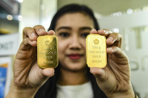 Petugas menunjukkan sampel emas batangan di Butik Emas Logam Mulia, Jakarta, Senin (9/12/2019). Harga emas batangan PT Aneka Tambang (Persero) Tbk pada Senin (9/12) Rp 744.000 per gram, turun Rp 3.000 dibandingkan harga emas pada Minggu (8/12).