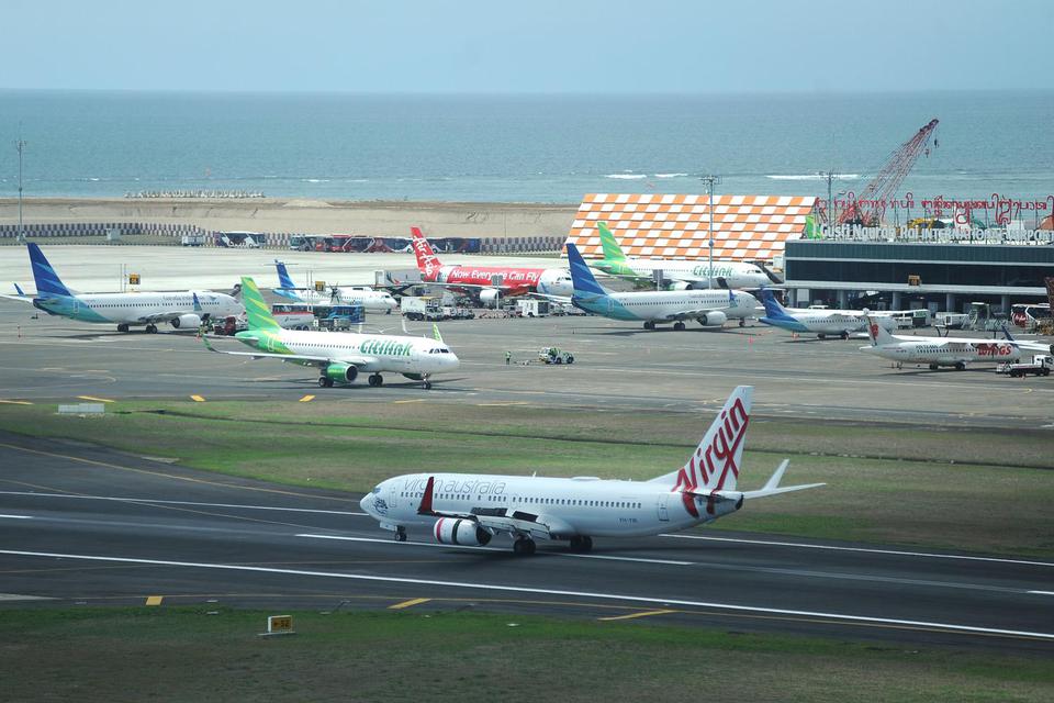 Sejumlah pesawat udara berada di apron dan landasan Bandara Internasional I Gusti Ngurah Rai, Bali, Selasa (17/12/2019). 
