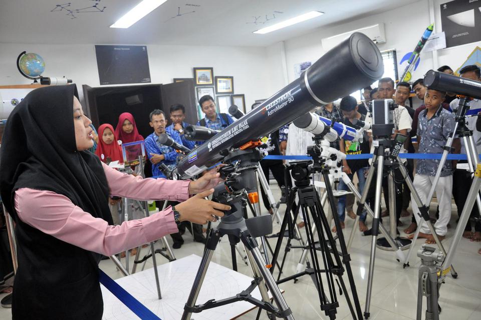 Petugas memperlihatkan peralatan teleskop untuk melihat fenomena gerhana matahari kepada pengunjung di Observatorium Ilmu Falak Universitas Muhammadiyah Sumatera Utara (UMSU) di Medan, Sumatera Utara, Kamis (19/12/2019). 