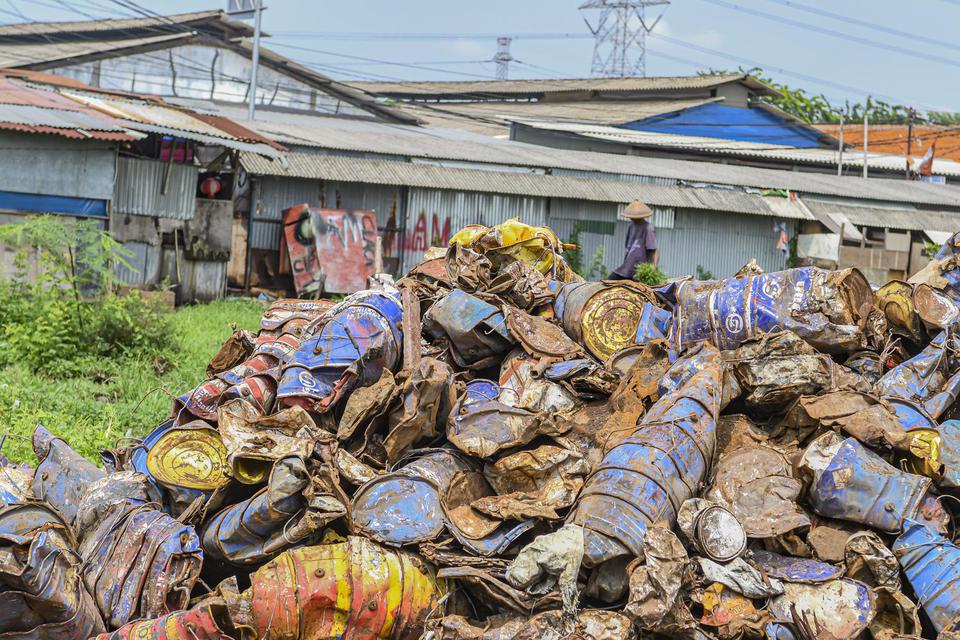 Warga beraktivitas di antara tumpukan limbah Bahan Beracun dan Berbahaya (B3) di Jakarta, Jumat (27/12/2019). Limbah B3 dari kegiatan industri maupun rumah tangga yang terbuang ke lingkungan akan berdampak pada pencemaran dan kesehatan manusia. 