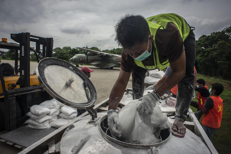 Petugas TMC memasukan garam ke tabung penampung garam atau consul dalam pelaksanaan Operasi Teknologi Modifikasi Cuaca (TMC) yang menggunakan pesawat CN 295 di Skadron Udara 2 Lanud Halim Perdanakusuma, Jakarta, Jumat (3/1/2020). Operasi tersebut bertujua