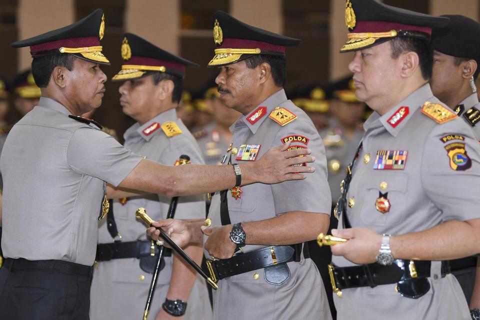 Kapolri Jenderal Polisi Idham Azis (kiri) menyematkan tanda jabatan kepada pejabat baru Kapolda Metro Jaya Irjen Pol Nana Sujana (kedua kanan) dan pejabat baru Kapolda Nusa Tenggara Barat (NTB) Irjen Pol Tomsi Tohir (kanan) saat Serah Terima Jabatan Pejab