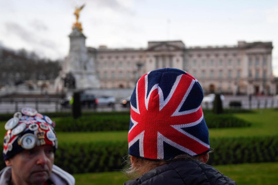 Seorang penggemar keluarga kerajaan memakai topi dengan bendera Union Flag diluar Istana Buckingham di London, Inggris, Kamis (9/1/2020). binance