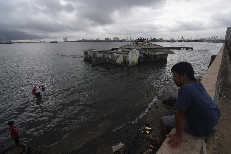 Sejumlah anak bermain di dekat masjid yang terendam air laut akibat penurunan tanah dan kenaikan permukaan air laut di Muara Baru, Penjaringan, Jakarta Utara, Senin (13/1/2020). Tim Geodesi Institut Teknologi Bandung menemukan 23 daerah di Indonesia menga