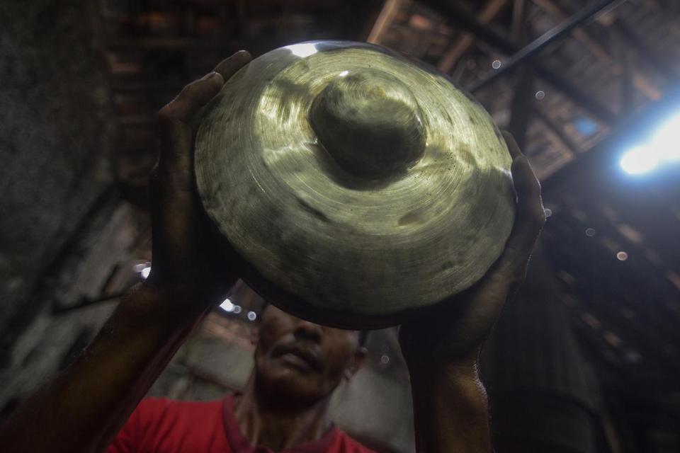 Perajin memeriksa bagian dalam alat musik bonang saat memproduksi gamelan di Galeri Gamelan Bah Omo, Cipageran, Cimahi, Jawa Barat, Rabu (22/1/2020). Gamelan Bah Omo yang ada sejak 1920 dan memasuki generasi ke-5 ini telah mengekspor gamelan ke berbagai 